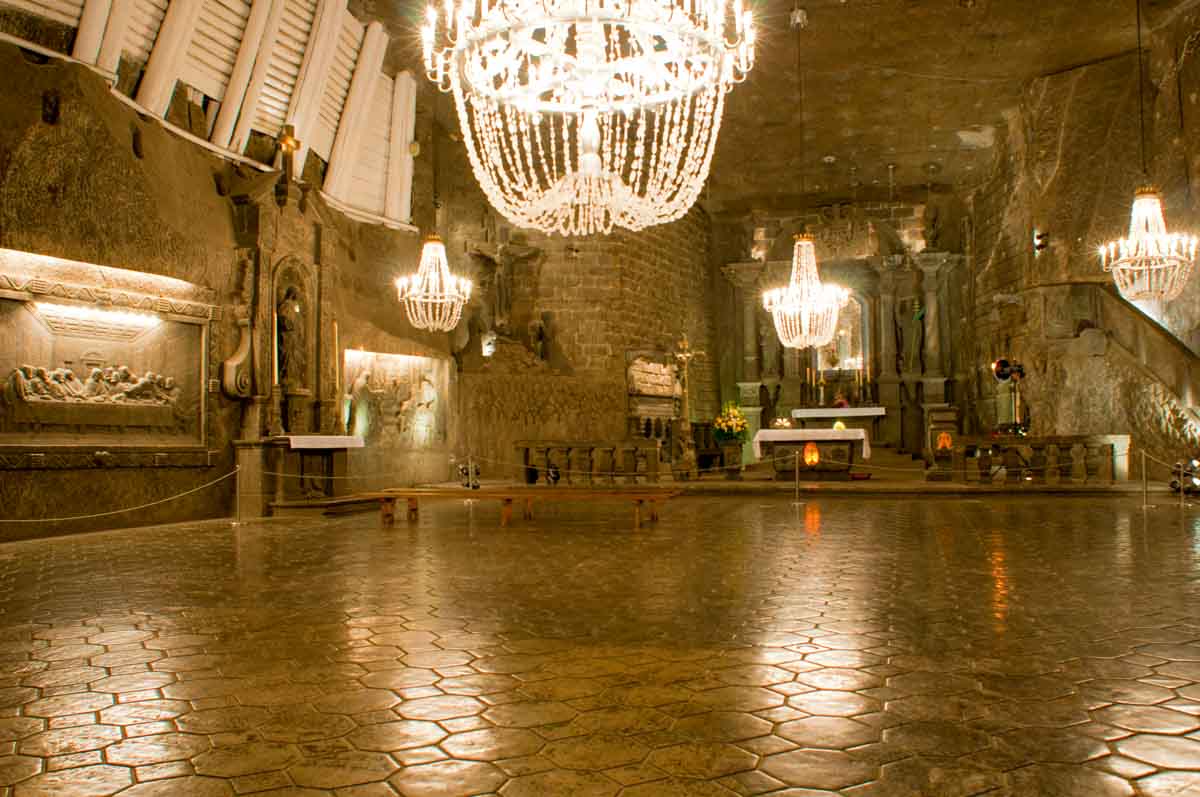 interior of chapel carved into a cave with wall reliefs and chandelier