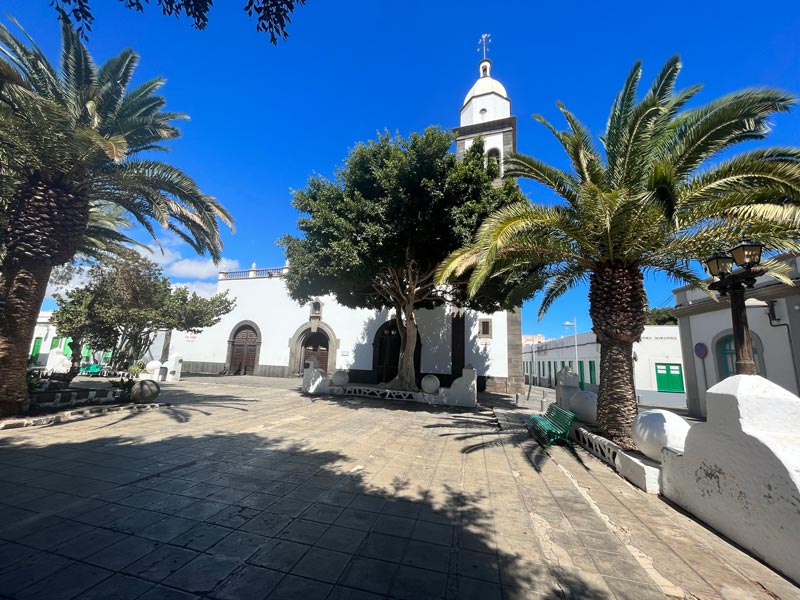 pretty colonial square with a whitewashed church with bell tower