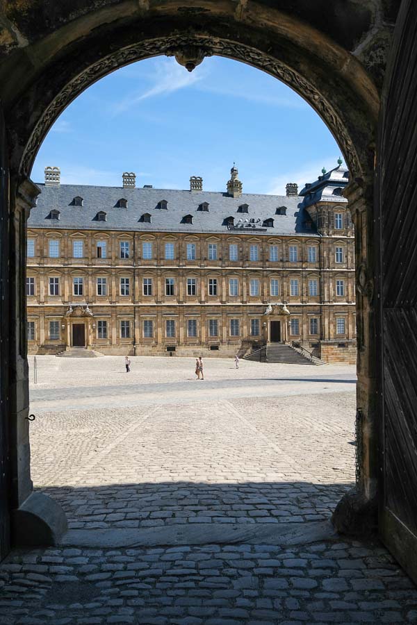 large cobblestoned plaza viewed through arch