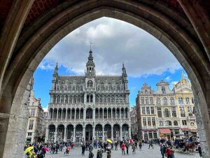 view of gothic buildings of brussels grand place seen through an arch