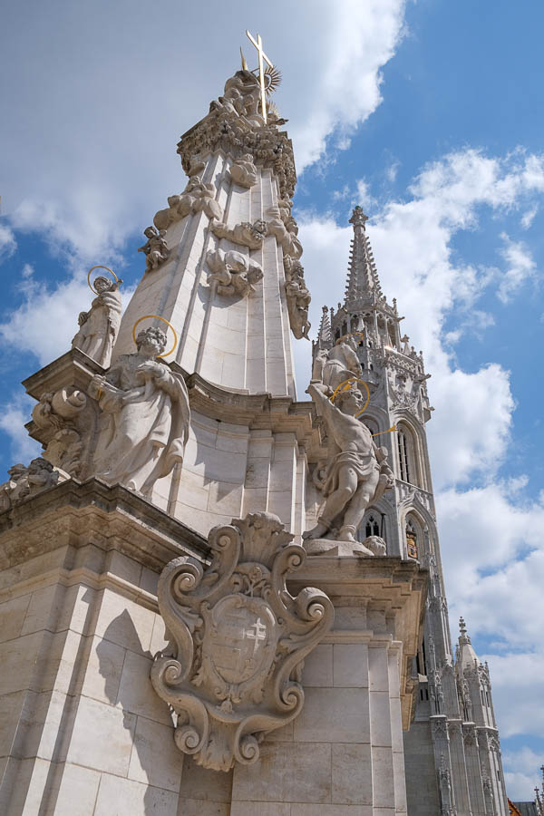 ornately carved stone plague column with figures of saints