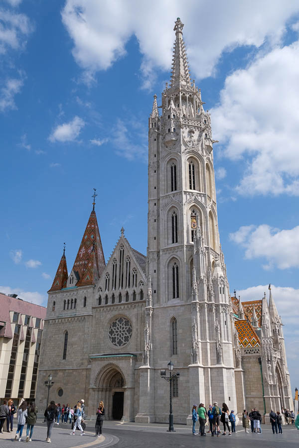 exterior of matthias church in budapest with tall tower and tiled roof