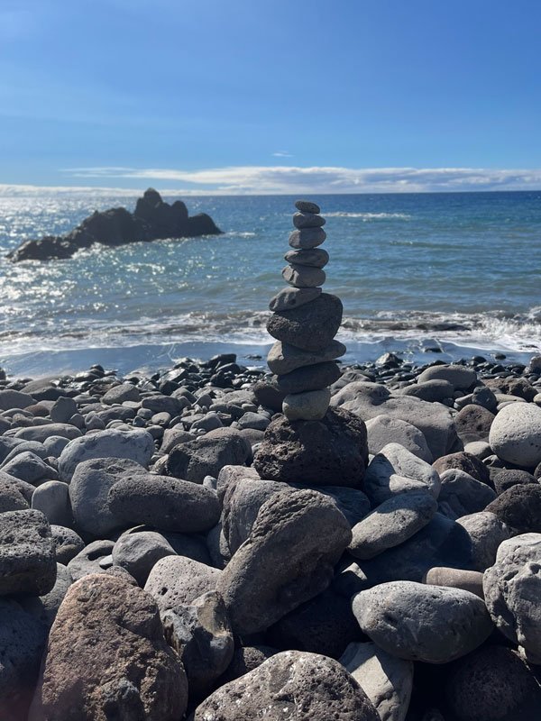 an arrangement of a pyramid of pebbles on the shore