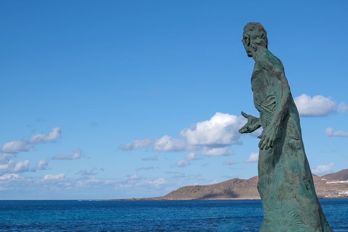 massive sculpture of a man looking out over canteras beach in las palmas