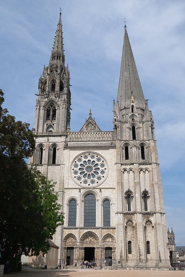 gothic facade of chartres cathedral with rose window and two pointed towers