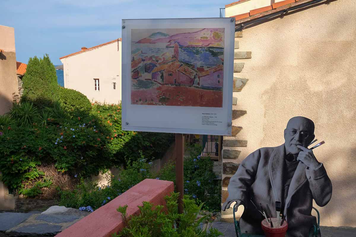 image of the painter matisse and a sign with one of his paintings in collioure france