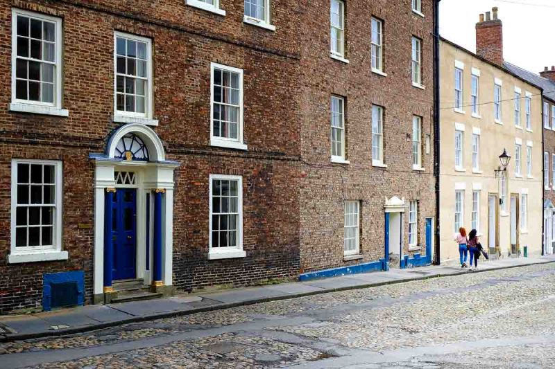 woman walking along cobbled street in durham