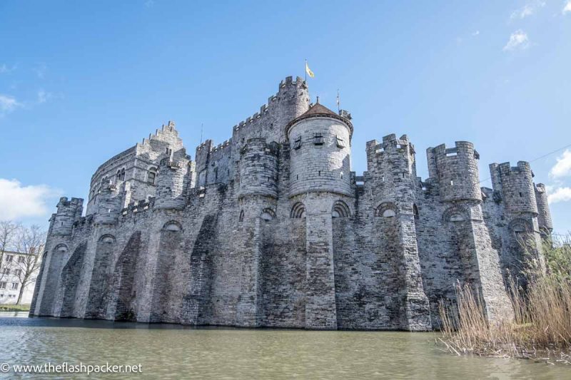 old grey stone castle surrounded by water