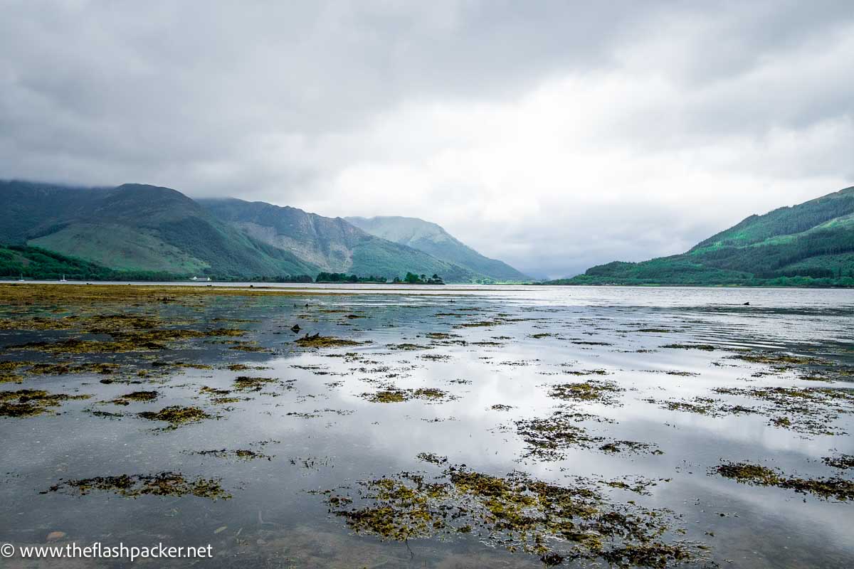 Still waters of loch in glen coe scotland with reflection of mountains