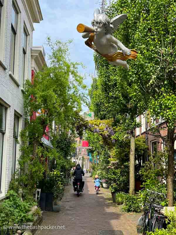 woman and child cycling along a narrow cobblestone street in haarlem