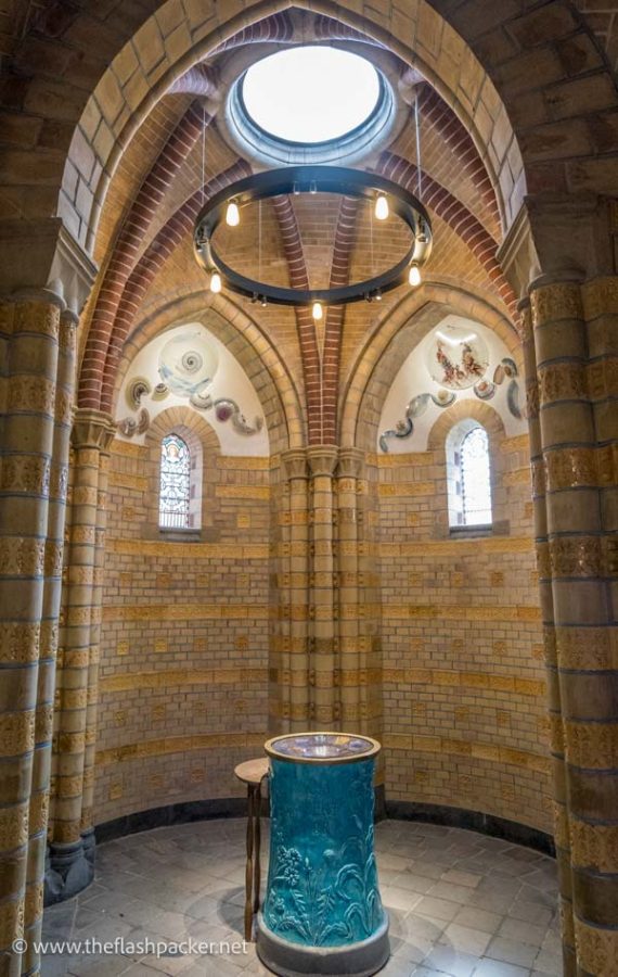 small chapel with brick walls and a central baptismal font