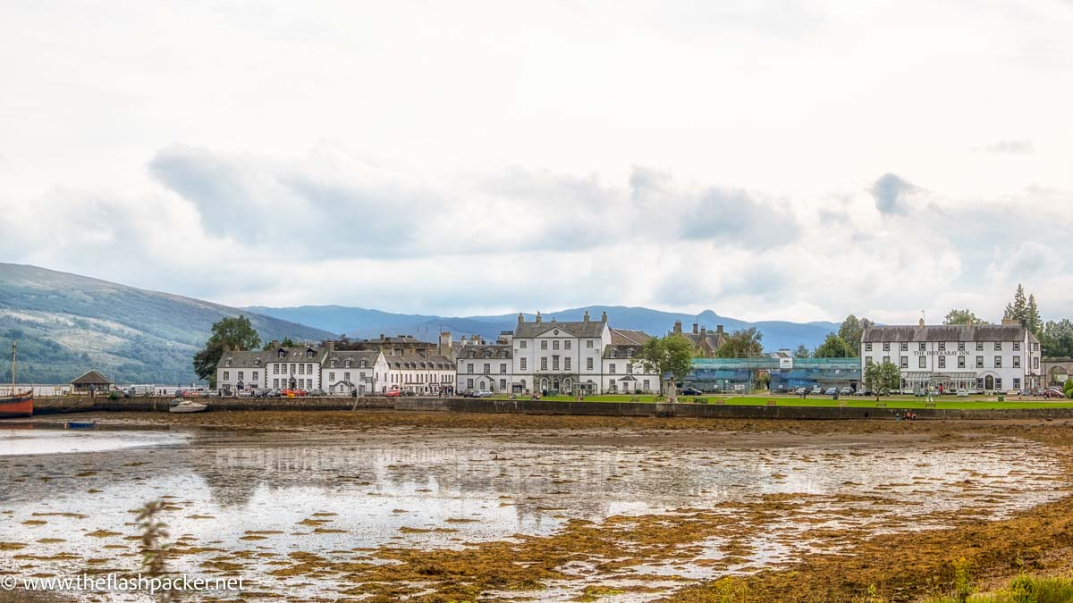 row of whitewashed cottages by side of loch in inveraray scotland