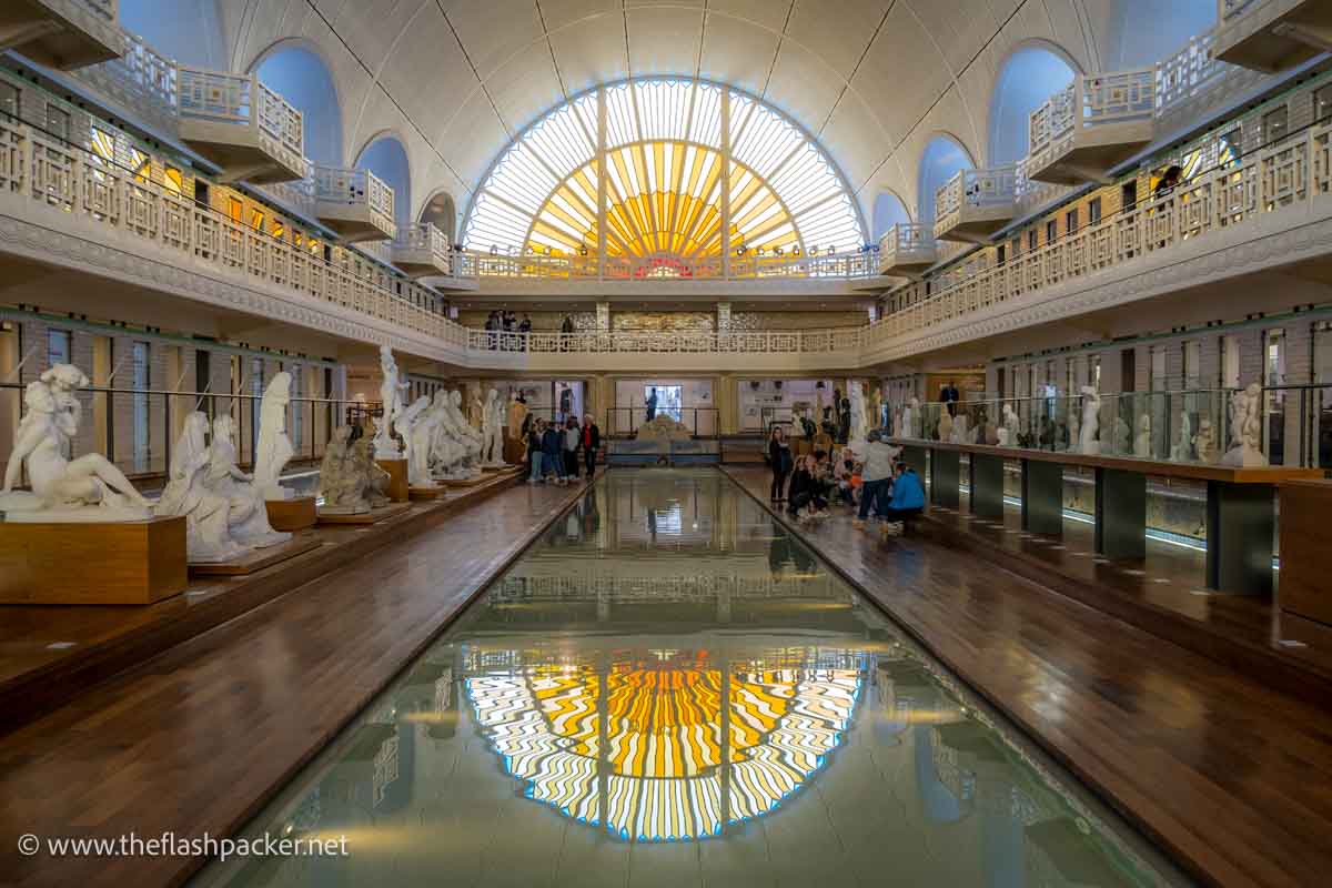 half-moon-shaped stained glass window reflected in the shallow water of an old swimming pool