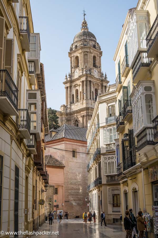 narrow street of old town with tower of cathedral in malaga spain