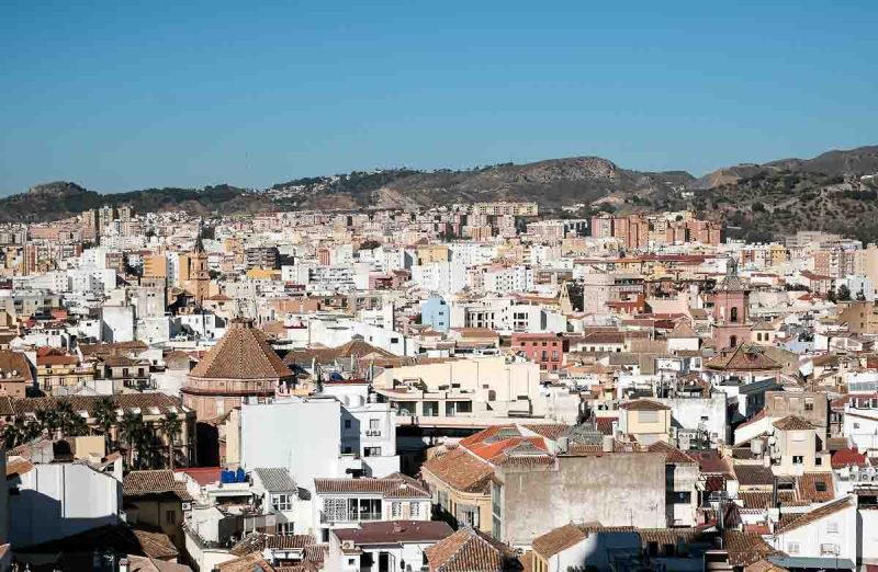 a view over the rooftops of malaga to the hills beyond