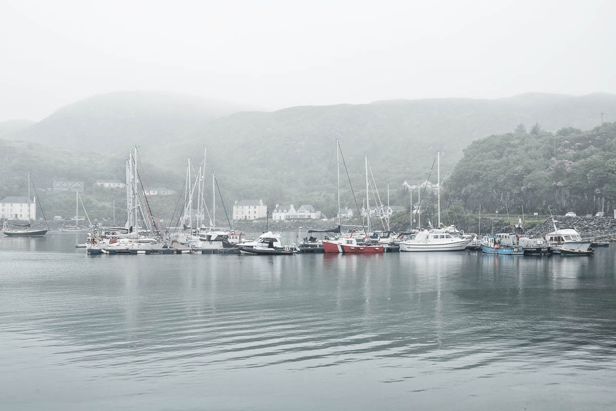 boats anchored in the misty harbour of mallaig scotland