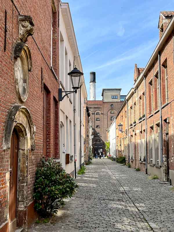 narrow cobblestone lane lined with red brick houses