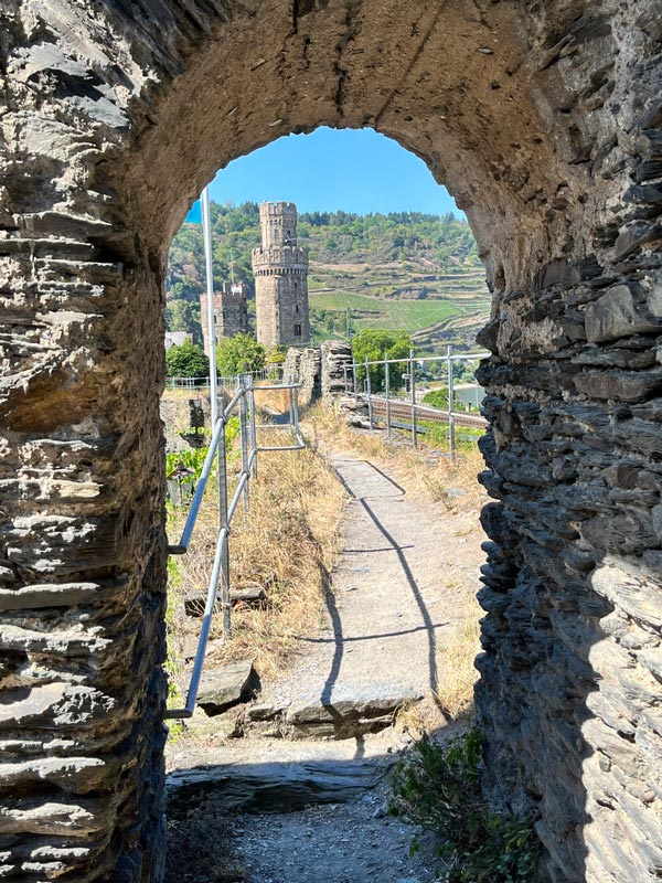 2 towers seen through the arch in the path along the town walls of oberwesel in germany