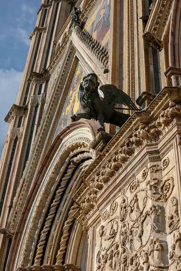 detail of stone tracery and sculpture of lion on exterior of duomo in orvieto italy