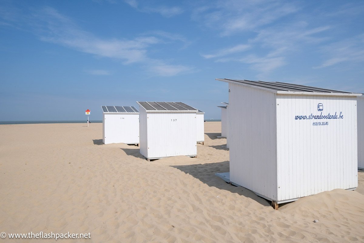 white wooden beach huts on a sandy beach in ostend belgium