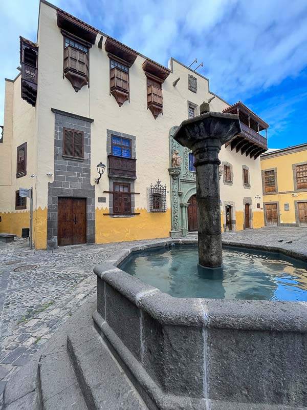 pretty small cobblestone square with fountain and beige and ochre colonial buildings