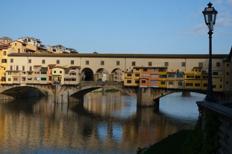 the ponte vecchio bridge in florence italy with reflections in river