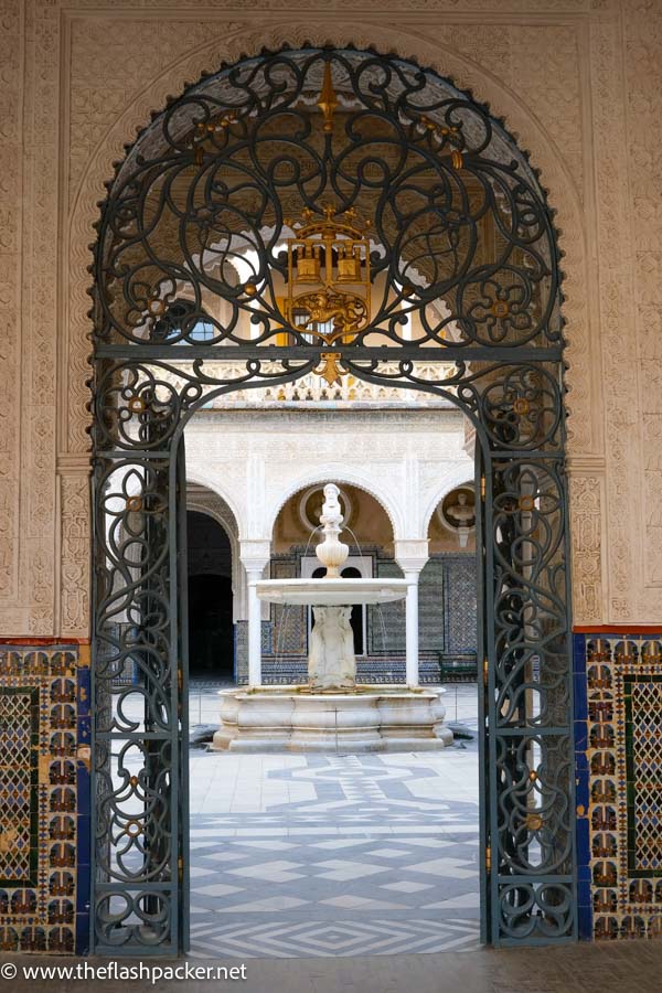 courtyard and fountain viewed through elaborate carved and tiled archway