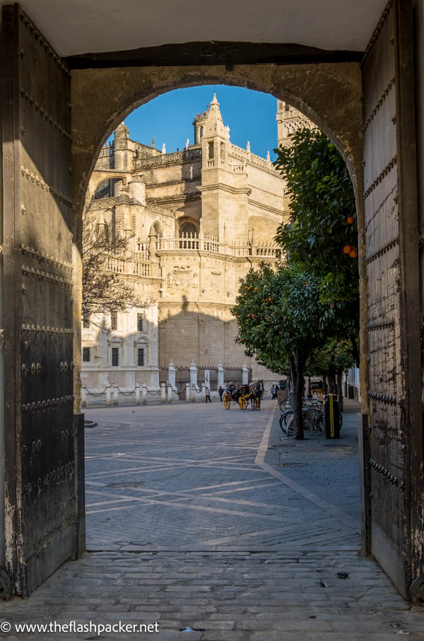 majestic seville cathedral seen through an arched gateway