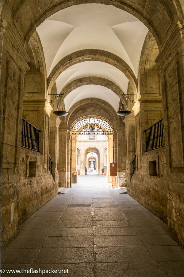 passageway with vaulted ceiling and wrought iron gateway