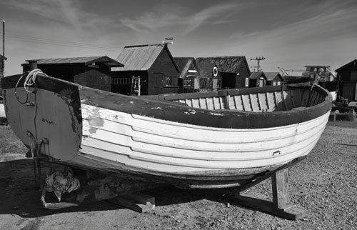 wooden boat in front of wooden harbour huts