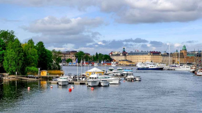 rover with boats and buildings on bank seen during one day in stockholm