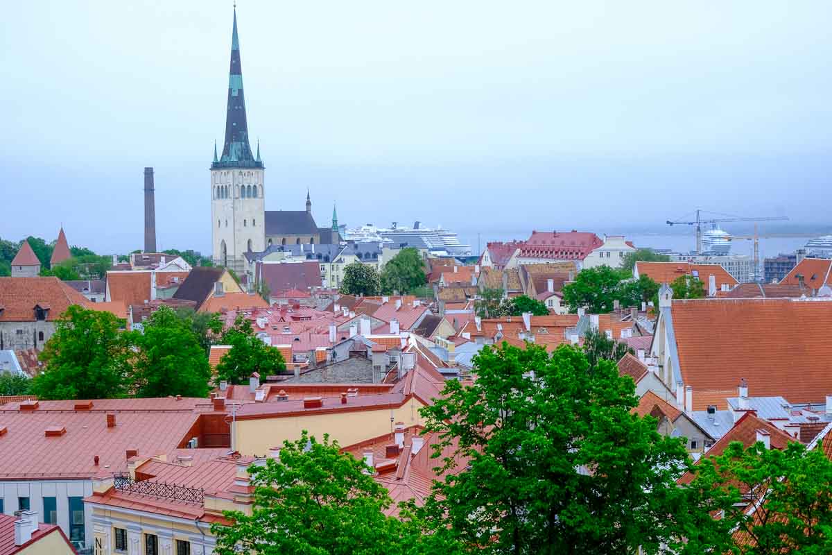 red roofs of tallinn with church spire and cruise ship in distance