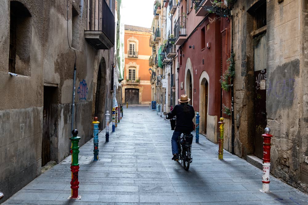 man cycling along medieval street