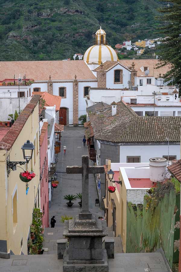 view of street and roorftops of teror in gran canaria with a large cross in the foreground