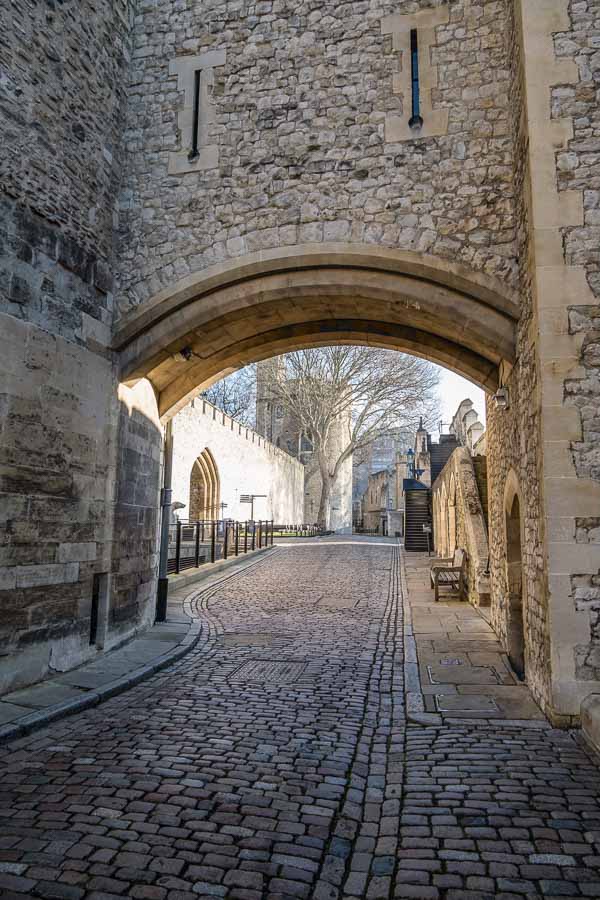 cobbled lane seen through arch at tower of london