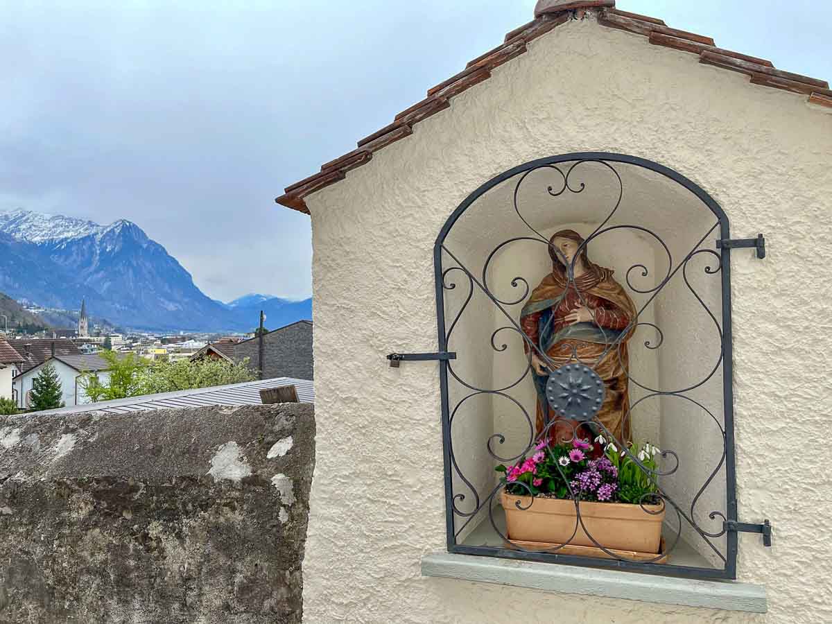 shrine set into the wall with an alpine valley in background