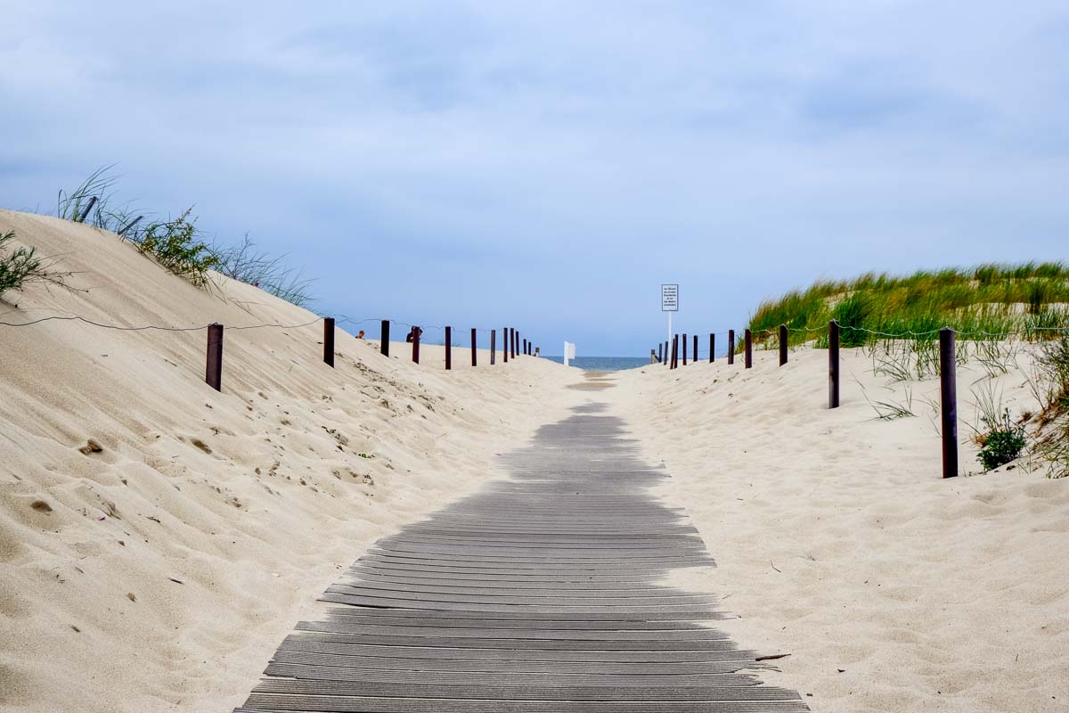 boardwlak leading to warnemunde beach through sand dunes