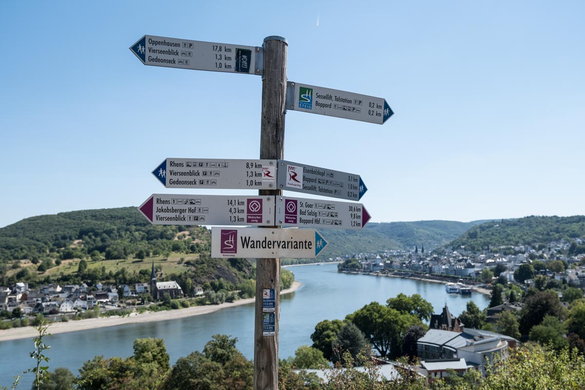 signpost on a hillside with a river in the background