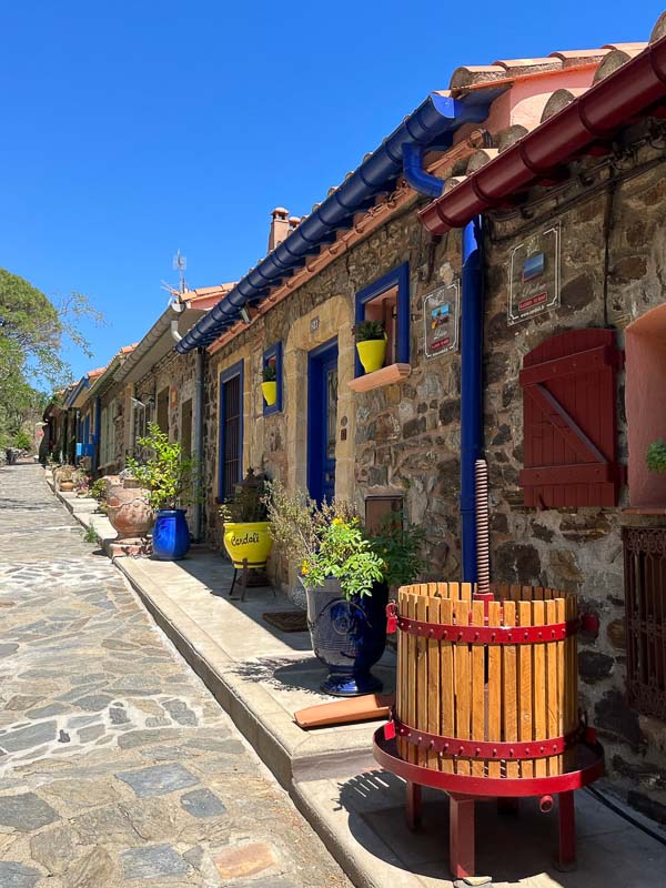 row of low stone cottages on a cobblestone street in old town collioure france