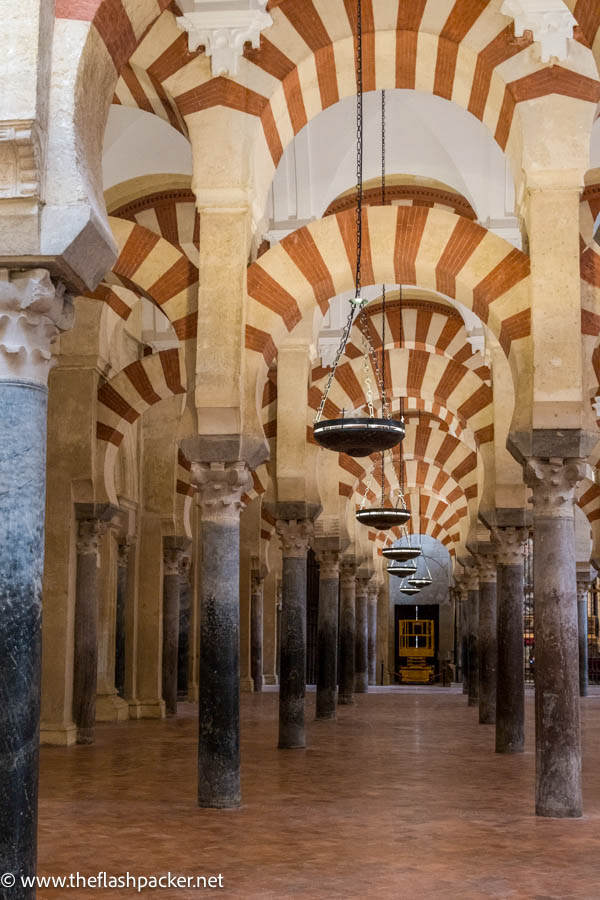 graceful red and white striped topped arches and columns of the mezquita in cordoba