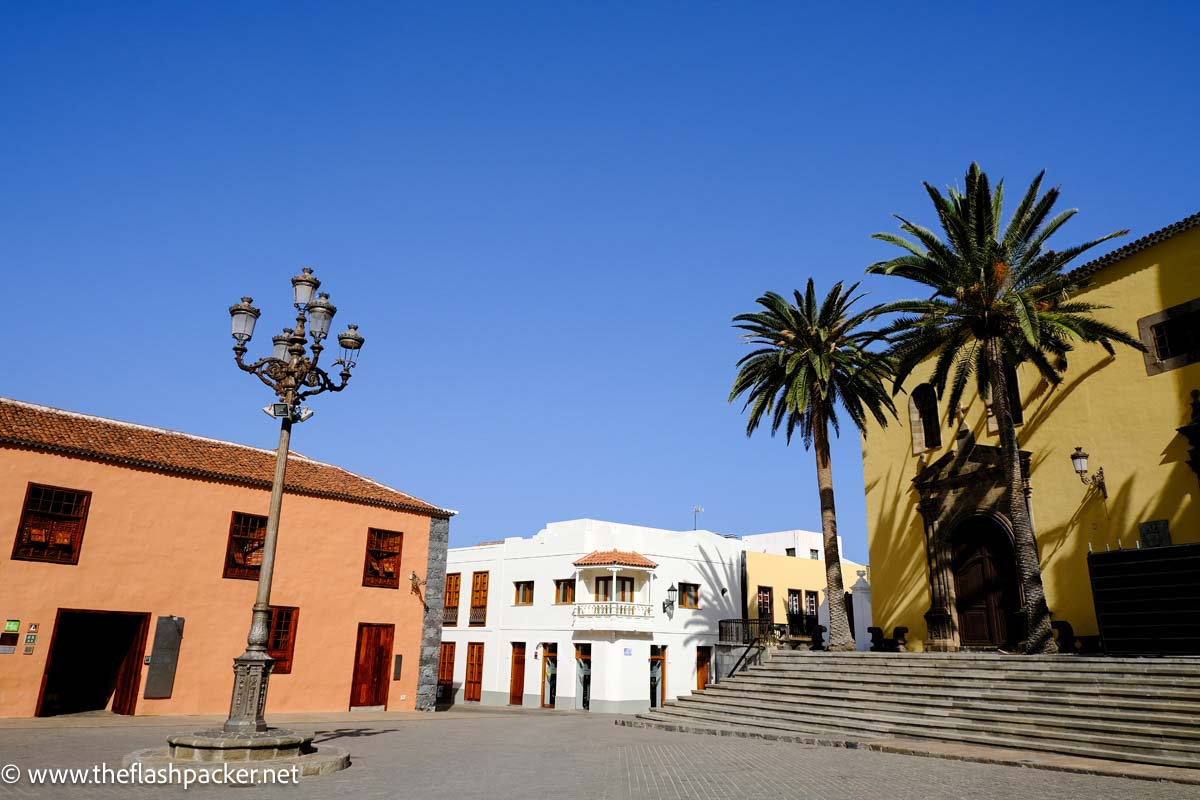 square with palm trees chucrch and 2-storey colonial buildings in garachico tenerife