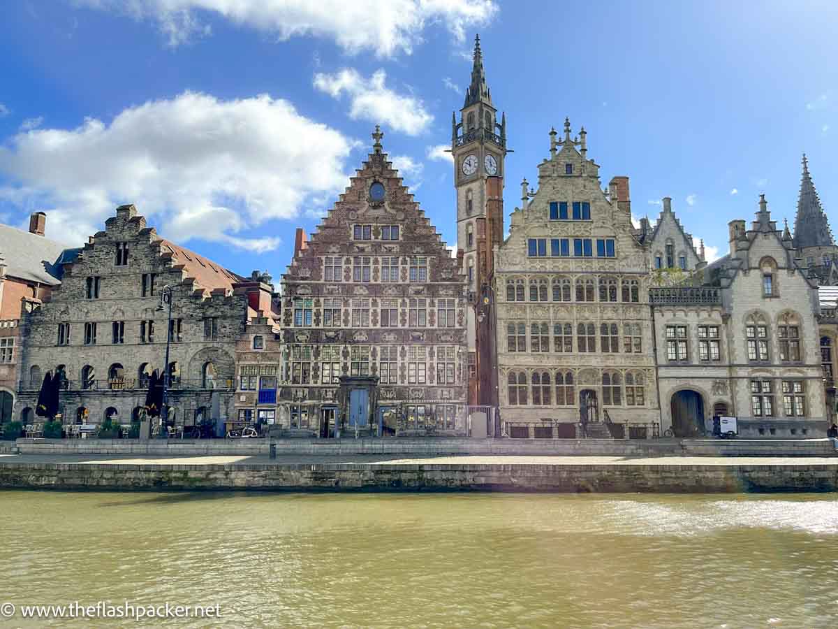 row of gabled medieval buildings along the side of a canal in ghent belgium