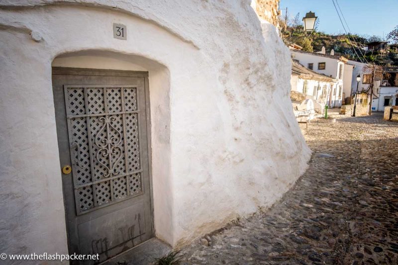 whitewashed building on corner of a cobblestone street in granada spain