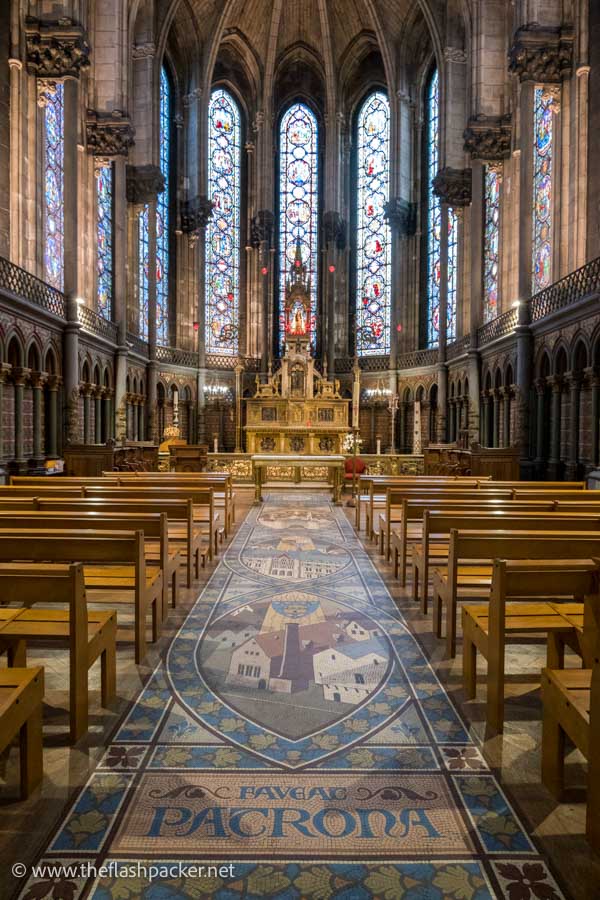 beautiful chapel with a mosaic floor and gilded altar and stained glass windows