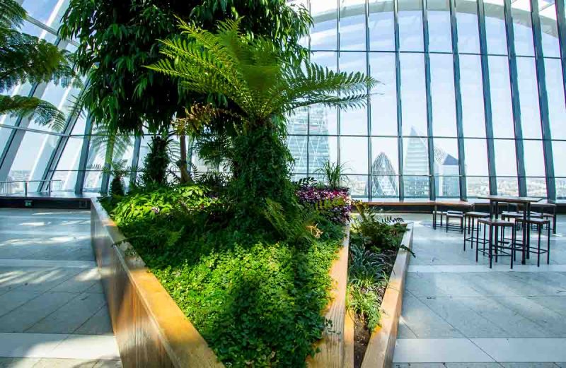 atrium with large glass windows looking out to londons skyscapers