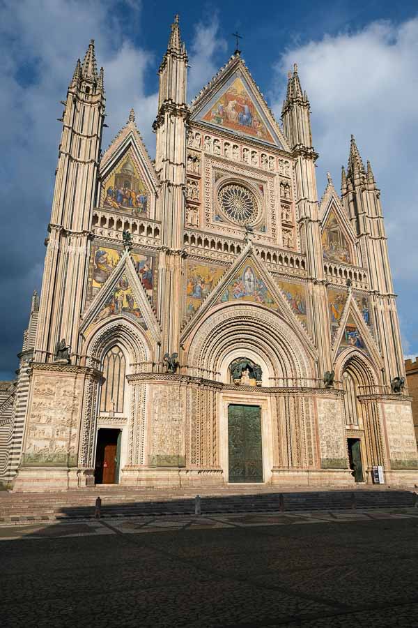 gothic facade of orvieto cathedral under a stormy sky