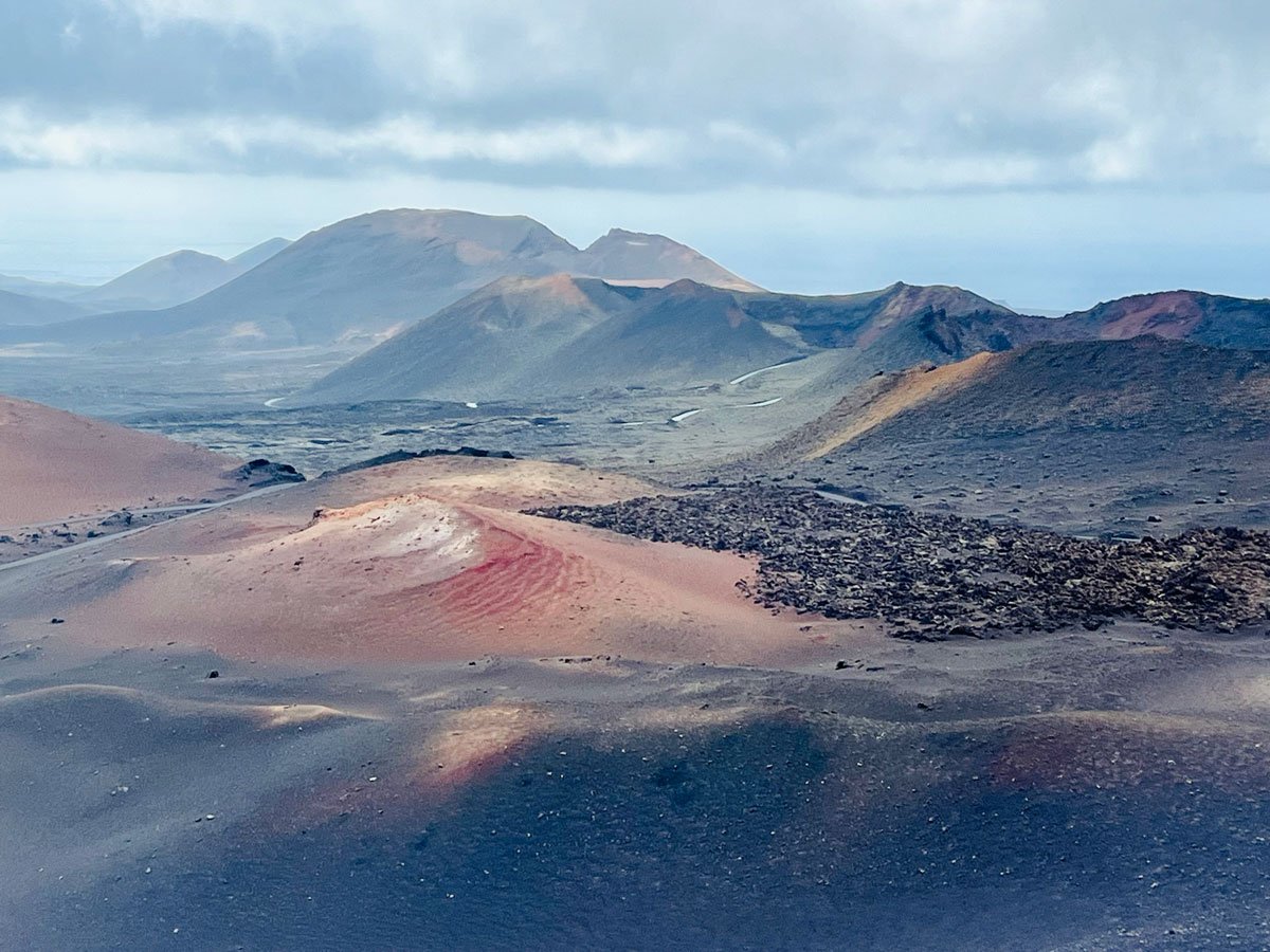 volcanic landscape with extinct volcanos and brown and red earth is one of the places to visit in Lanzarote in one week