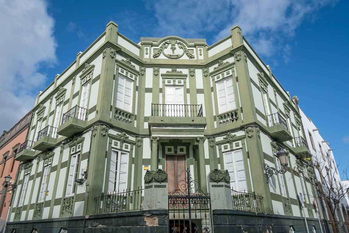 green and white building with wrought iron balconies in las palmas de gran canaria