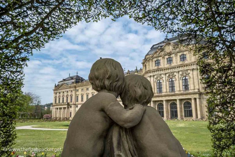 statue of 2 chubby children embracing in front of the wurzburg residenz in germany