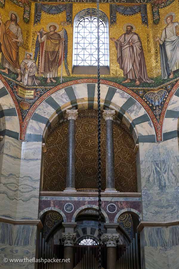 vibrant mosaics over an arched doorway of grey striped marble